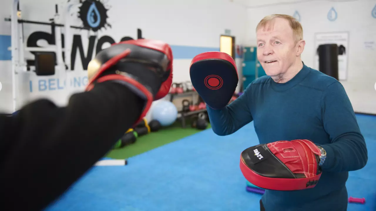 Man boxing with training pads