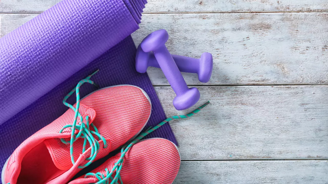 An image of pink trainers, purple weights and a purple yoga mat