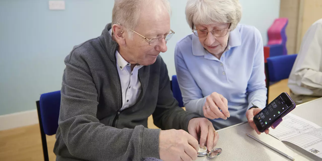A carer helps her husband to get his medication on time