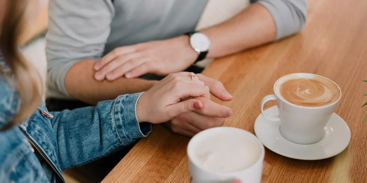 Couple holding hands having coffee