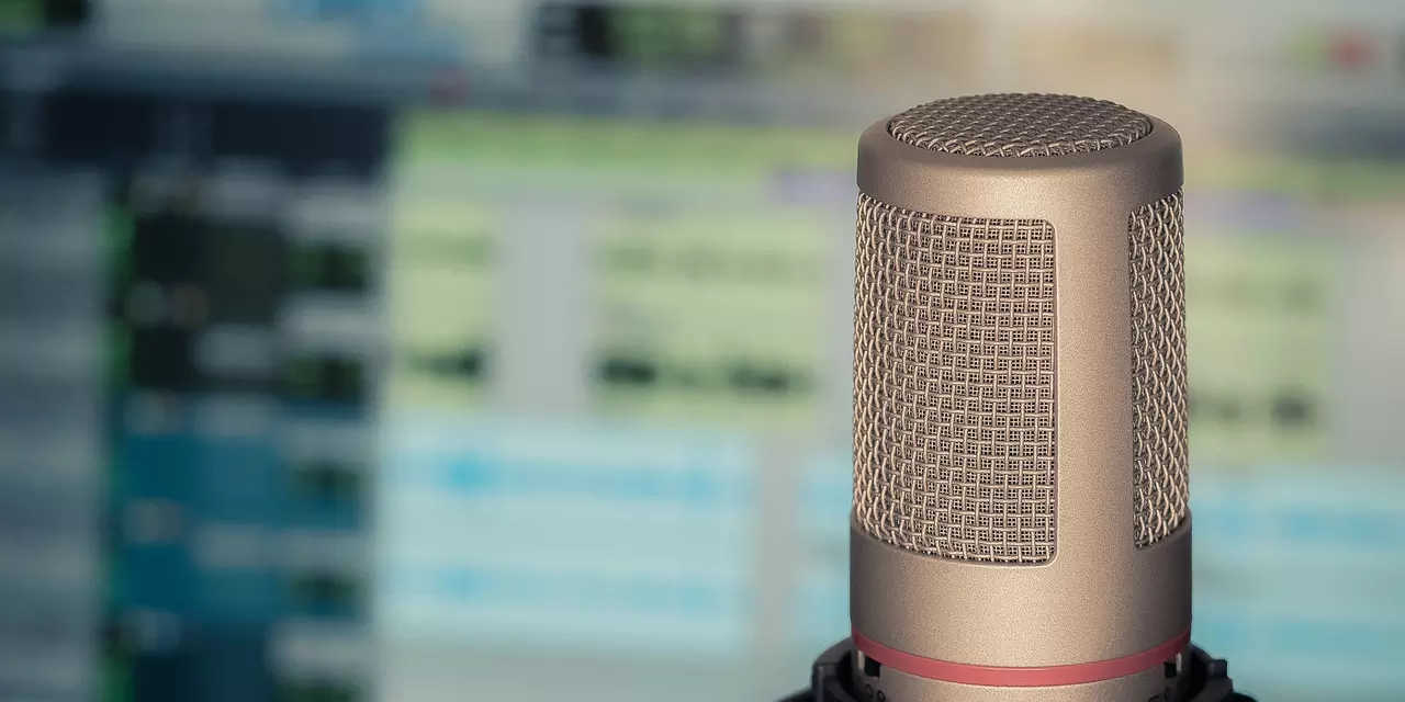 Podcast mic in front a blurred computer screen
