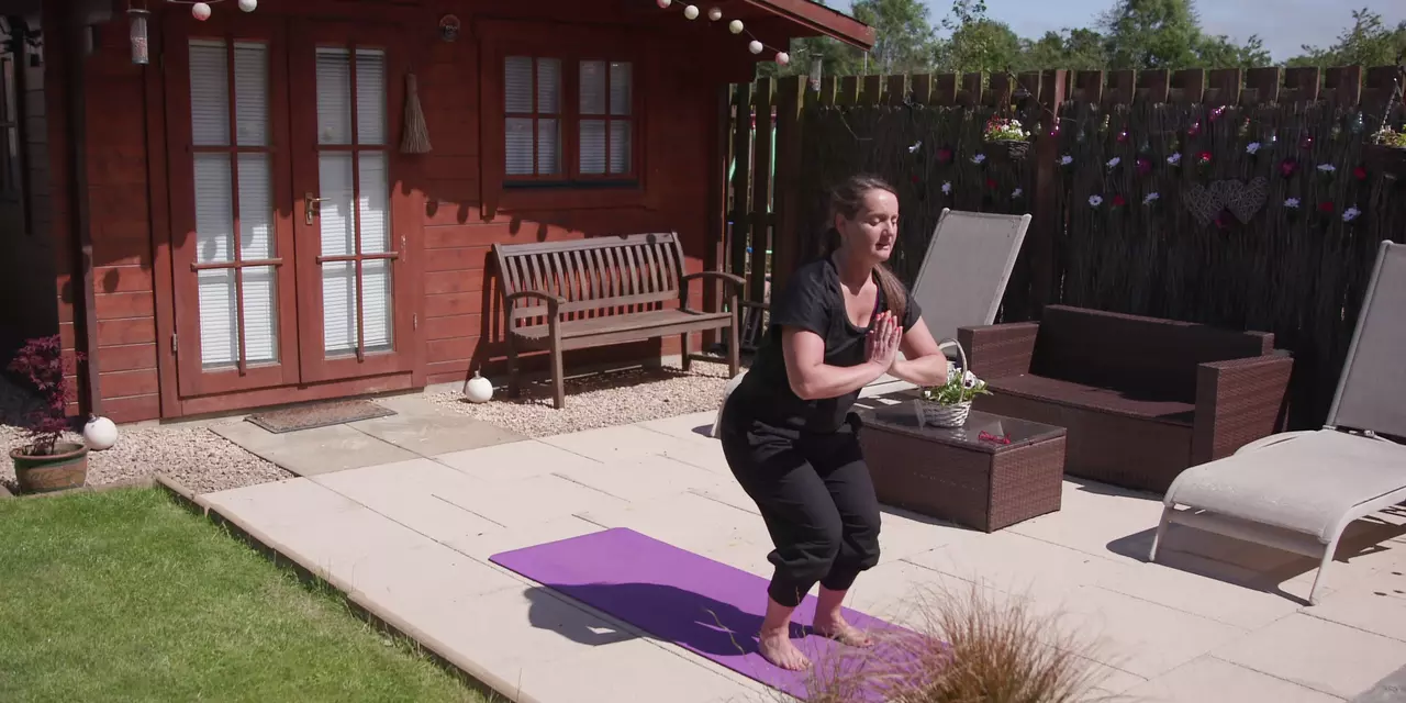 Woman with Parkinson's doing stretches in her back garden