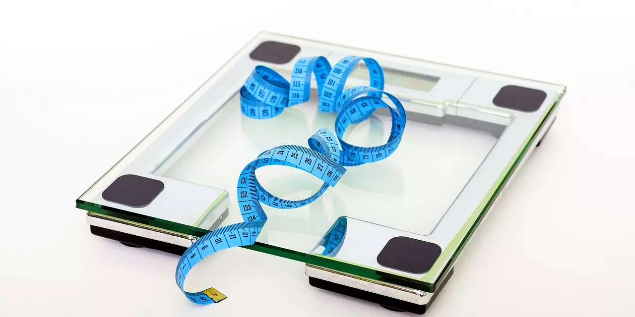 Set of bathroom scales with a blue tape measure rested on top