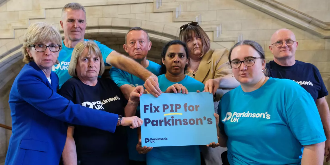 Campaigners in Parliament holding a fix PIP photo board