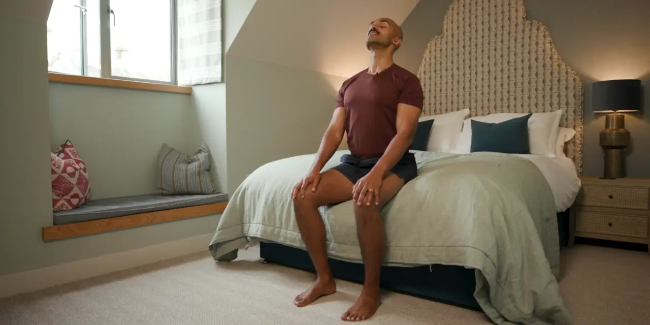 An image of a personal trainer in a sitting position while doing a mindfulness pose.