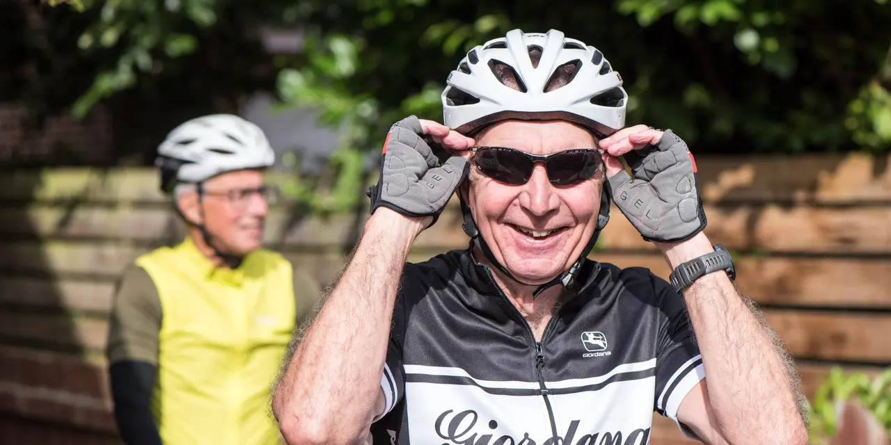 An image of two men getting ready to start cycling
