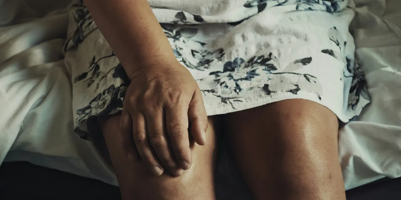 Woman holding her right knee in pain