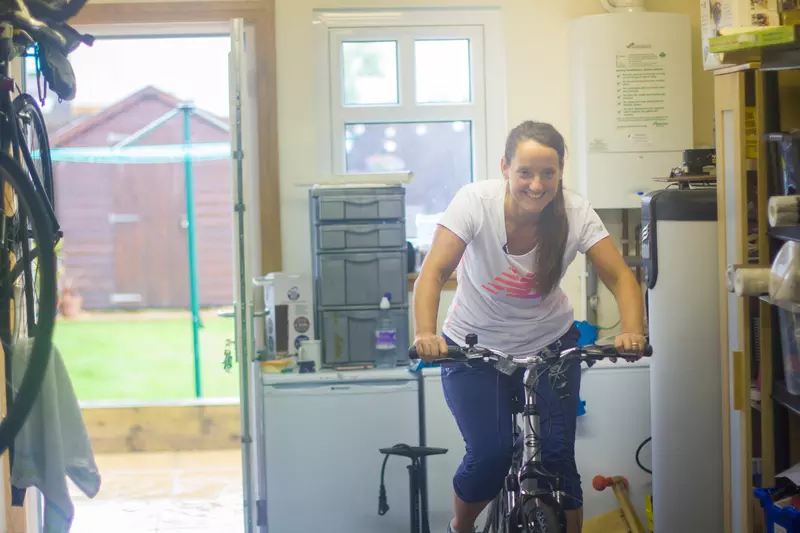 Lady on an exercise bike in garage