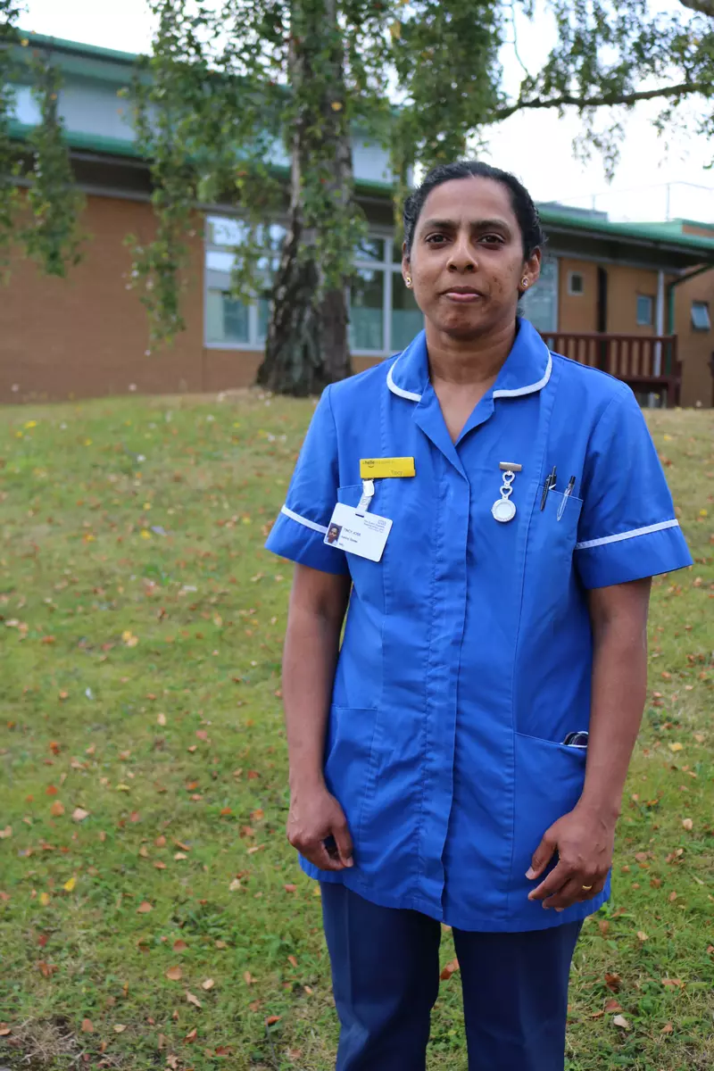 Tincy in her nurse's uniform standing outside