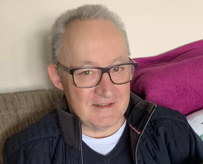 Gordon smiling at the camera. He has short grey hair and is wearing glasses with a black frame.