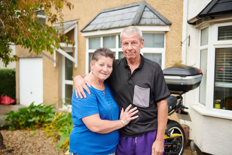 Mariette and Andy standing outside their house