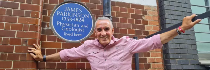 Joe Gregory smiling next to James Parkinson blue plaque 