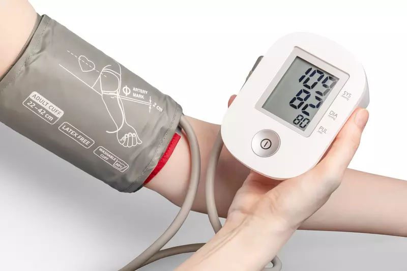 Blood pressure monitor and cuff wrapped around an arm