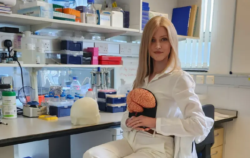 Dr Nataly Hastings holding a brain model in a laboratory